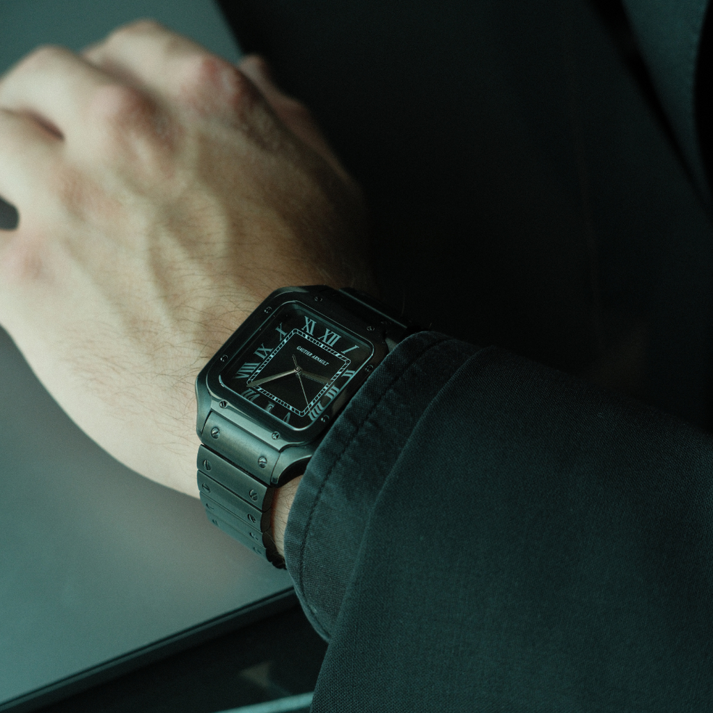 Person wearing a black watch with a dark background