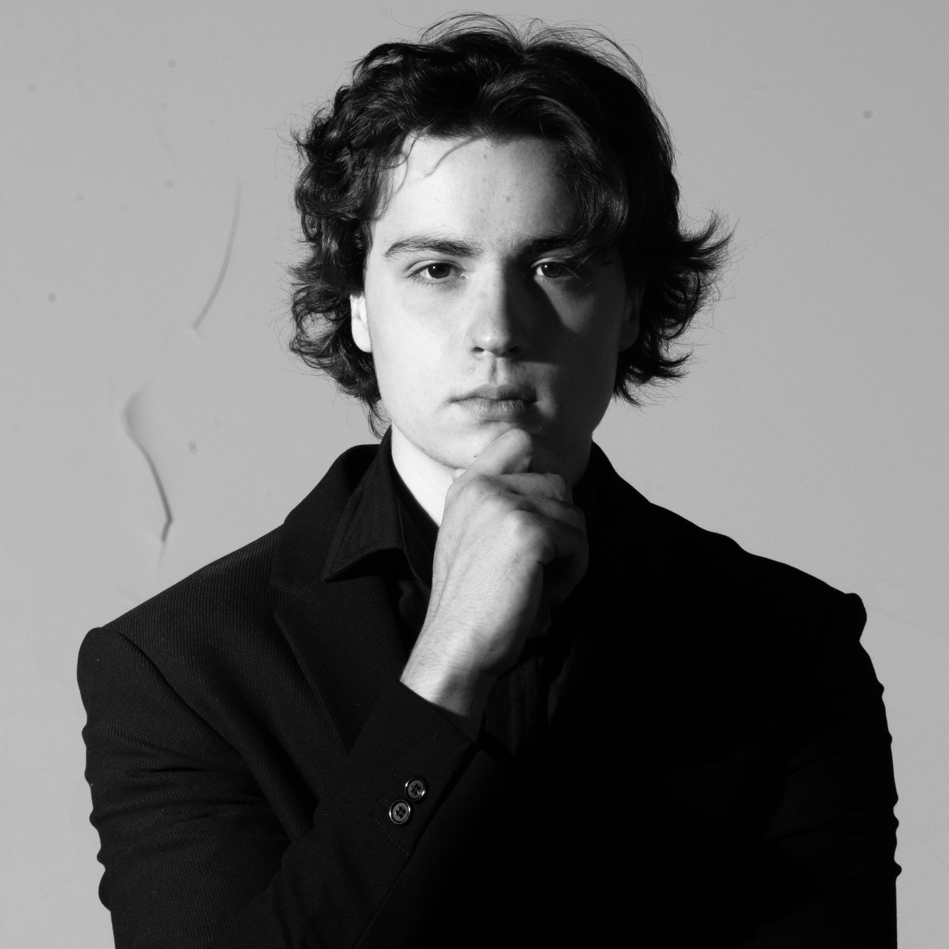 Black and white portrait of a person with a neutral expression against a plain background